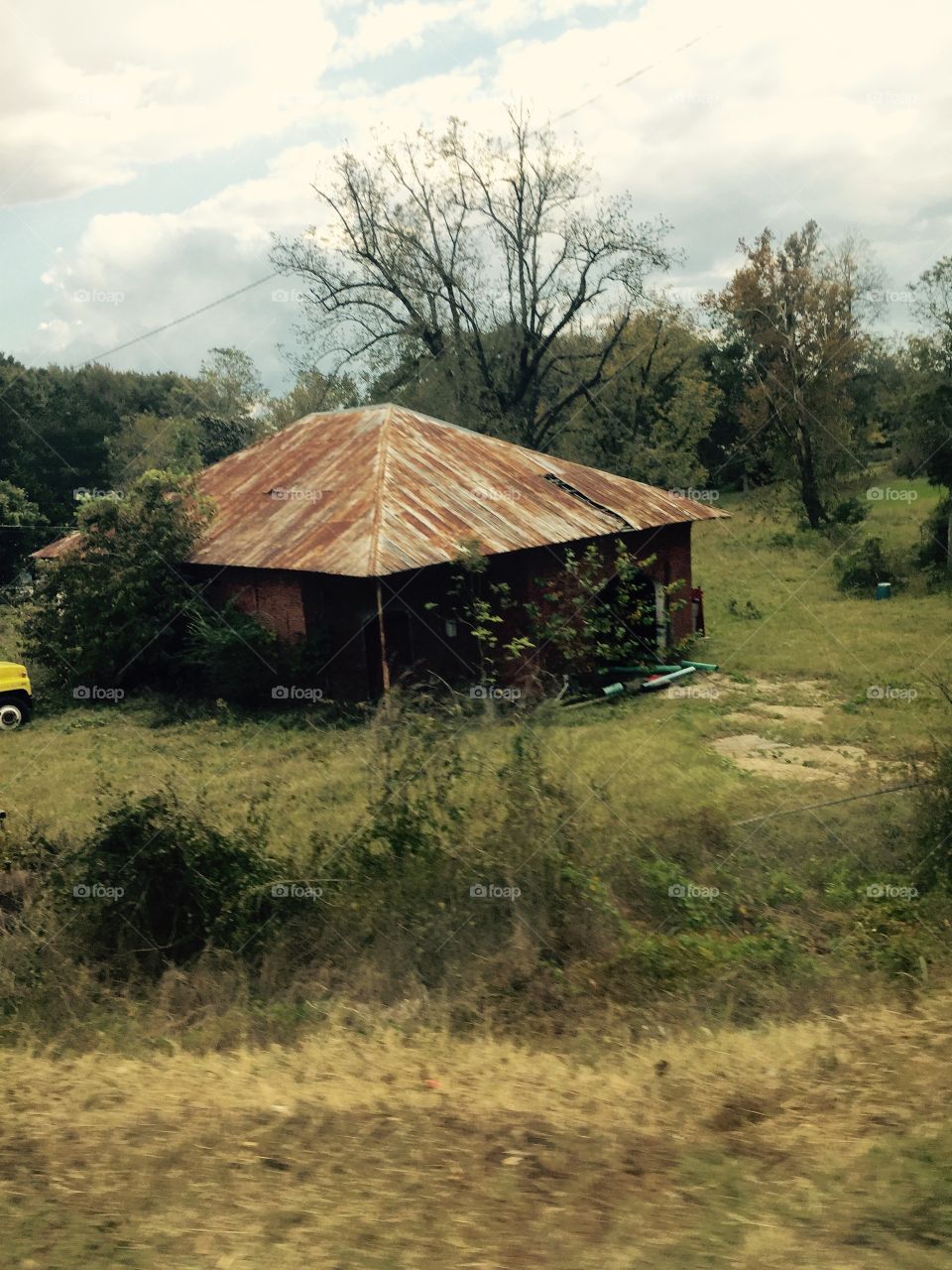 Old building with a rusted ton roof on the country. 