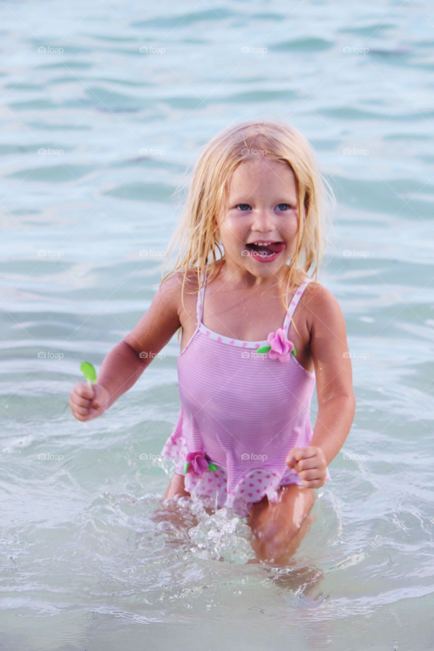 Pretty small girl standing in sea