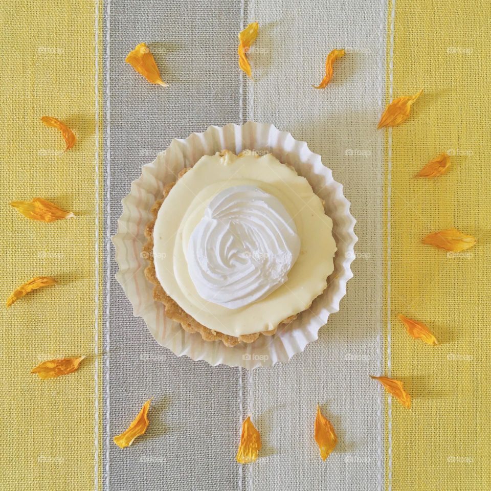 Summer moods:  flat lay of a sunny lime cheese tart decorated with chrysanthemum petals