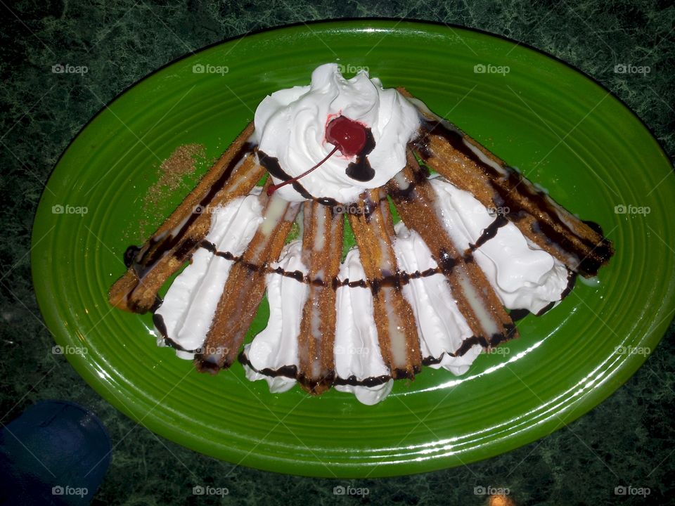 Churros con chocolate. Mexican dessert with whipped cream and chocolate 