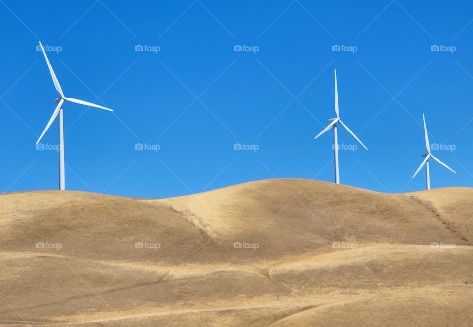 Massive wind turbines generate clean energy on a California hillside