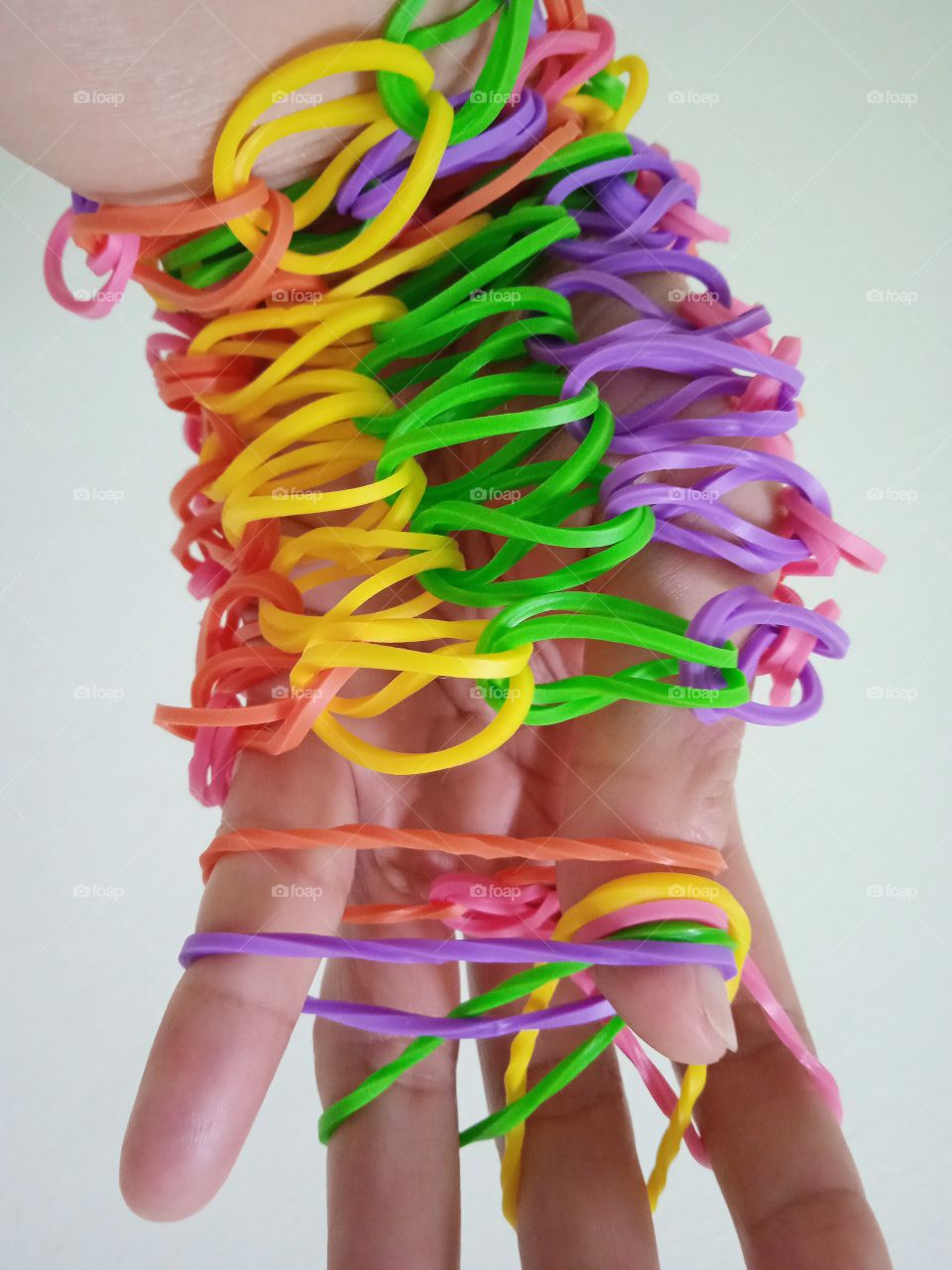 Colorful rubber bands around the hand.