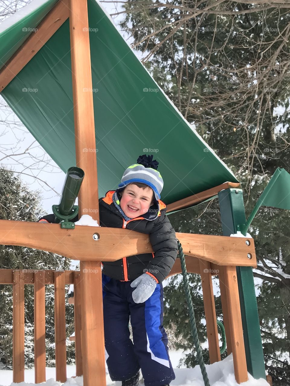 Child in treehouse in winter