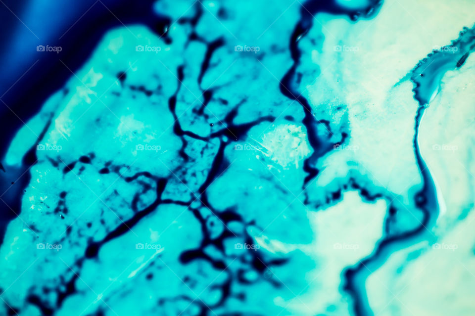 The ink to refill the printer cartridge was spilled onto the white washbasin and the paints blended into abstract drips and patterns.