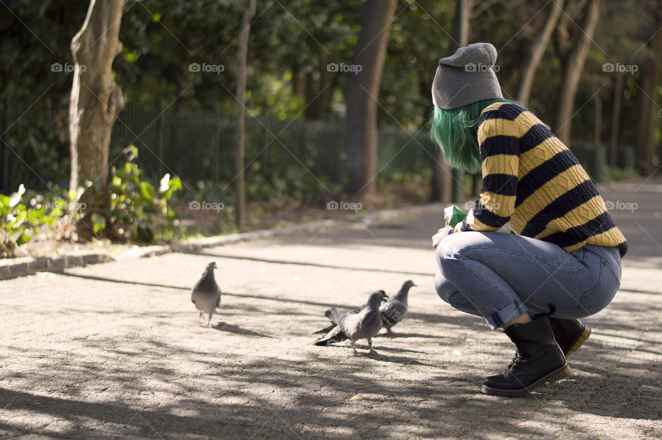 Alternative girl feeding pigeons