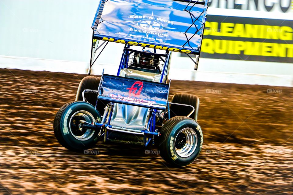 410 Outlaw Sprint Car drifting on a high banked dirt track Action Photos 
