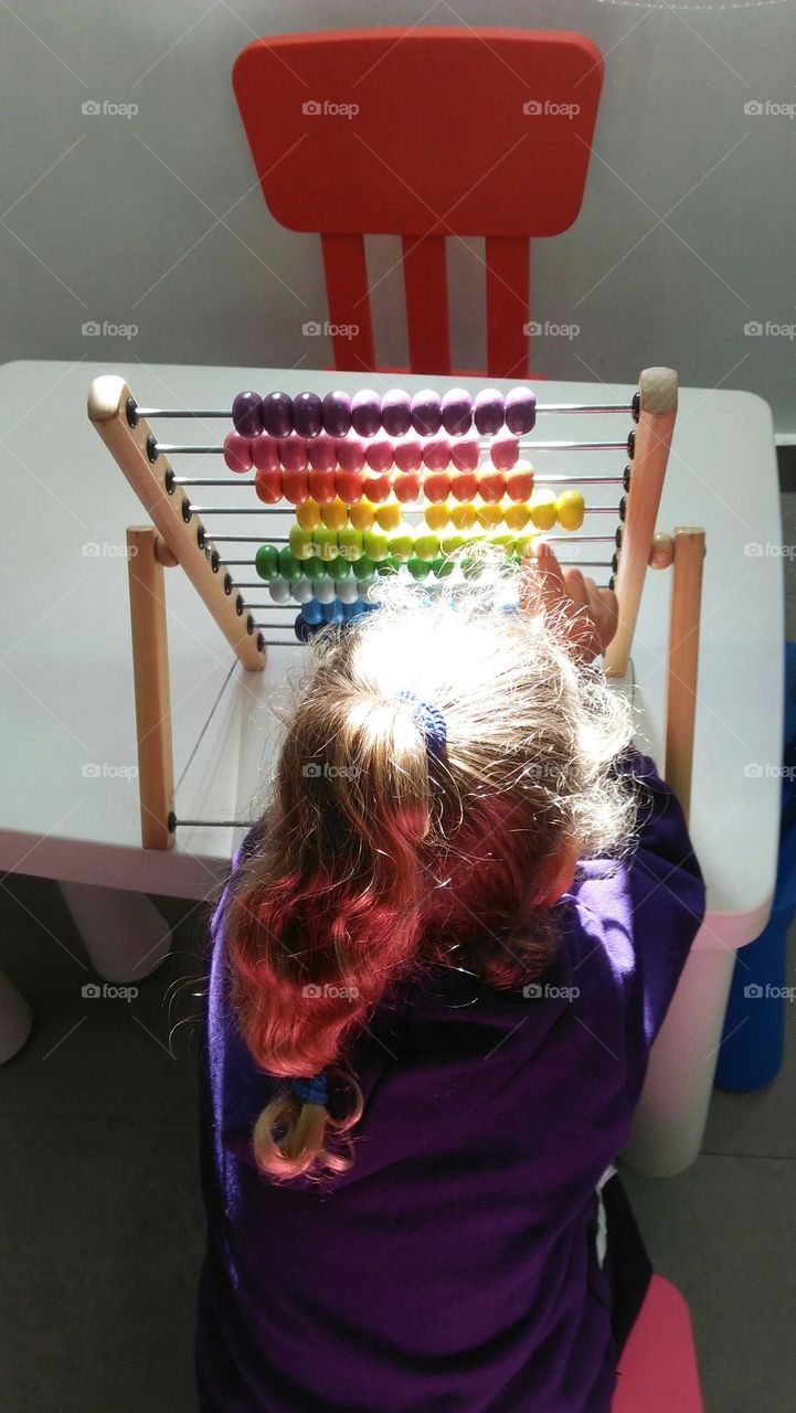 A child plays by Colored pellet setup.