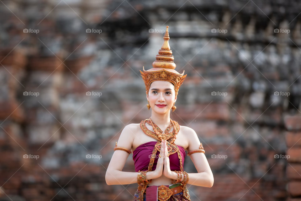 portrait of an Asian woman in Thai traditional clothes are standing against Temple