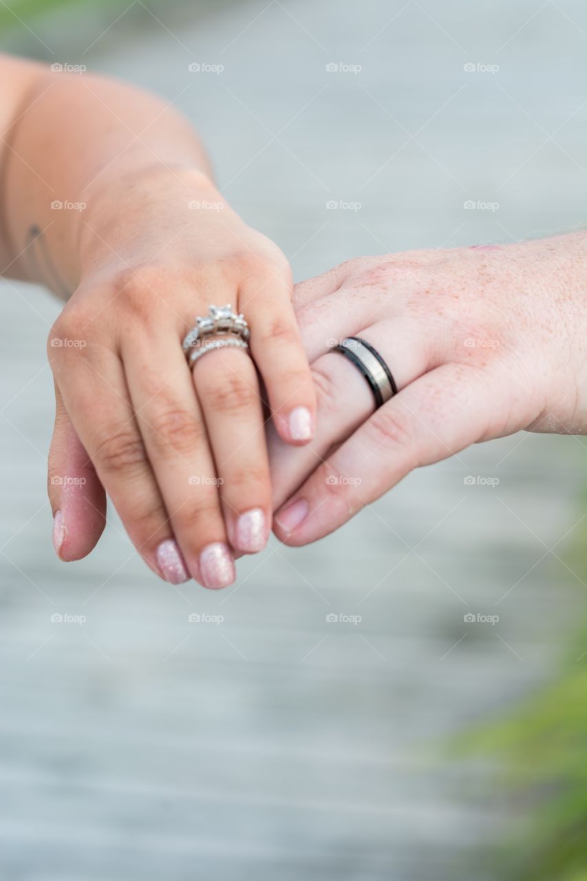 Bride and groom hands with wedding rings 