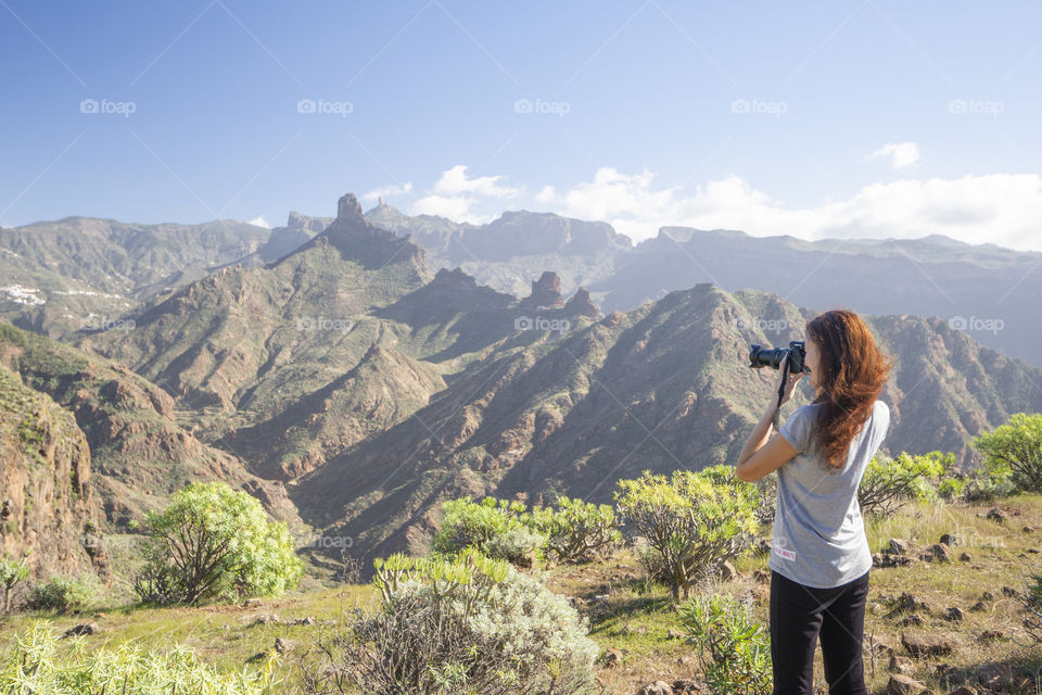 Girl photographs mountains for summer memories