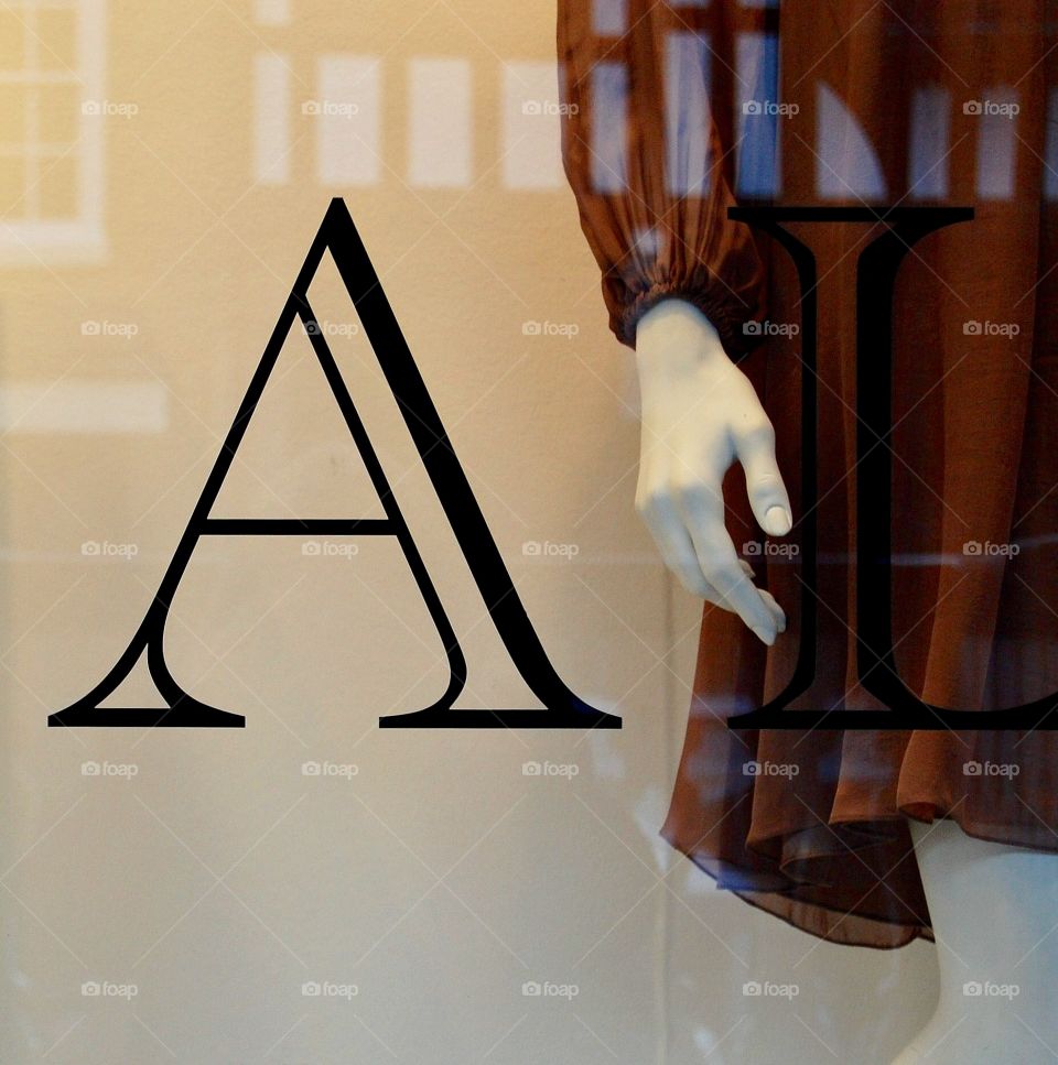 Reflection in shop window with mannequin and the letter A