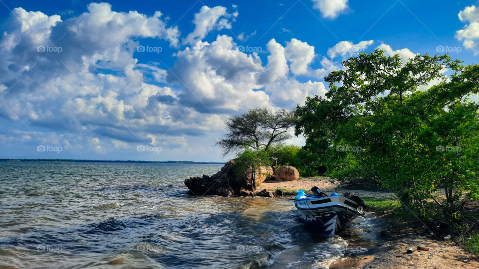 Beautiful day at a small island of Kokilai lagoon. Boat trip with perfect sunny weather. Sunny sky, blue waters and beautiful sky with clouds.