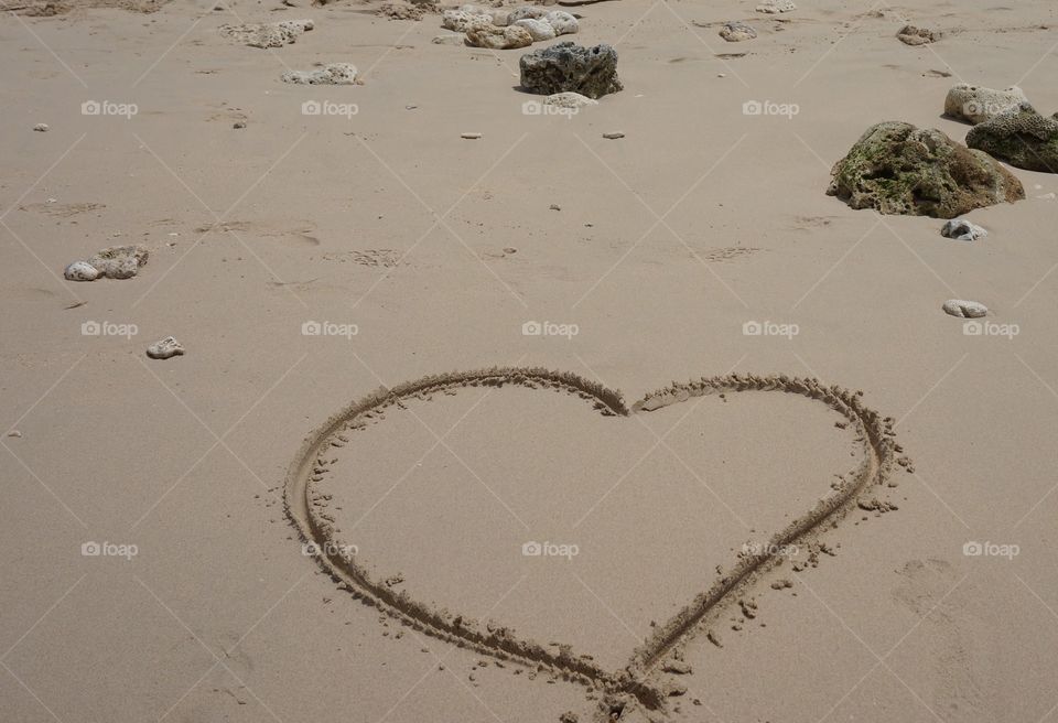 Beach with heart in sand. Heart drawn in sand at the beach in Barbados.