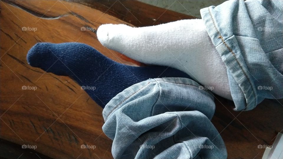 Pés masculinos com meias de cores diferentes.