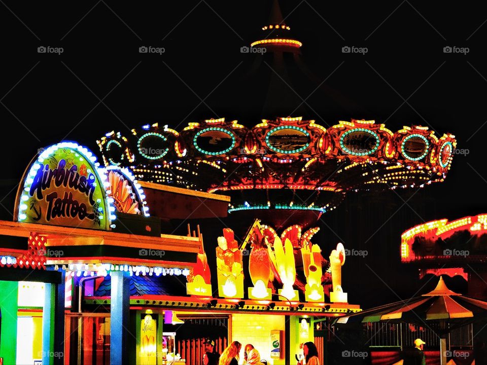 Bright neon lights of a carnival ride at night