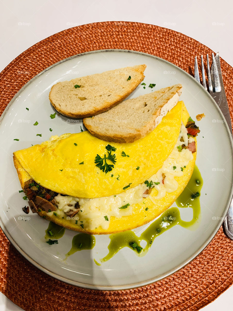 An omelette dish on an orange tile on a tablet. Omelette is a typical dish for breakfast and light meals. Taken with bread.