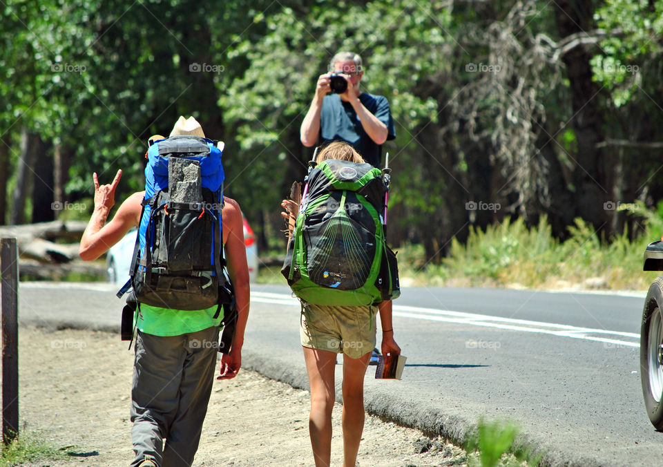 Story, hikers being photographed in the street of Yosemite national park