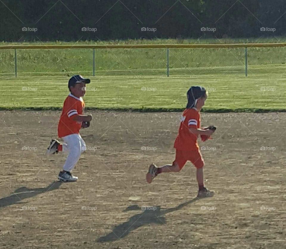 Children running on Baseball field