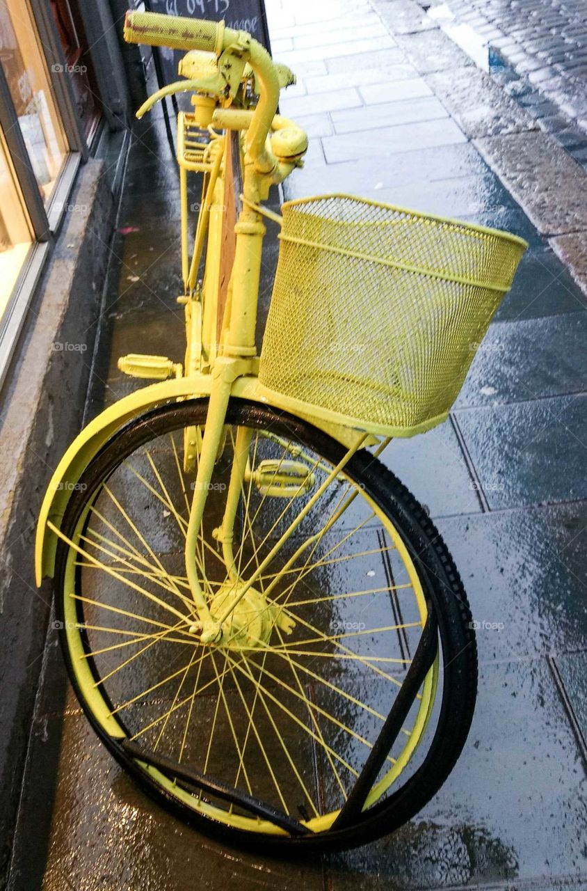 Yellow basket bicycle on sidewalk