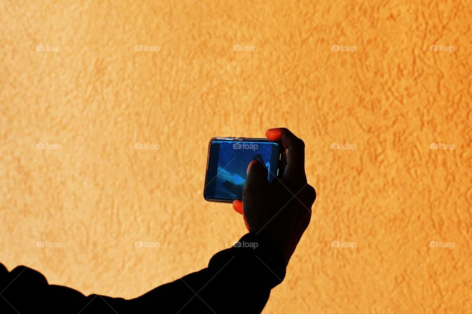 A man takes a balcony selfie with a beautiful sunrise unfolding behind him off the Atlantic city coast.
