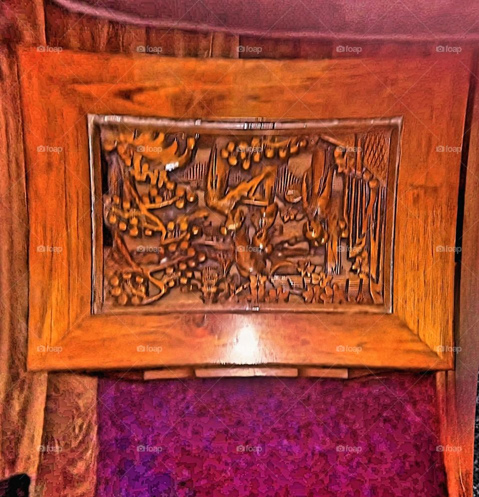 A  cherry wood stained side table with a beautiful carved, inlaid scene of Asian trees.