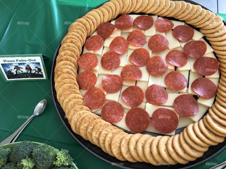 TMNT themed birthday party food with cheese, pepperoni and crackers to look like pizza