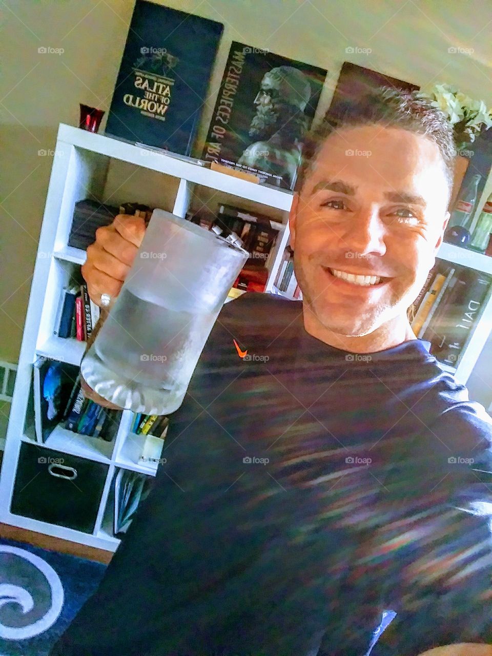This is me celebrating 5 years 6 months and 7 days of sobriety from alcohol. when the only thing you have in an iced mug on a Saturday night is water...life's good. I also love my book collection behind me.
