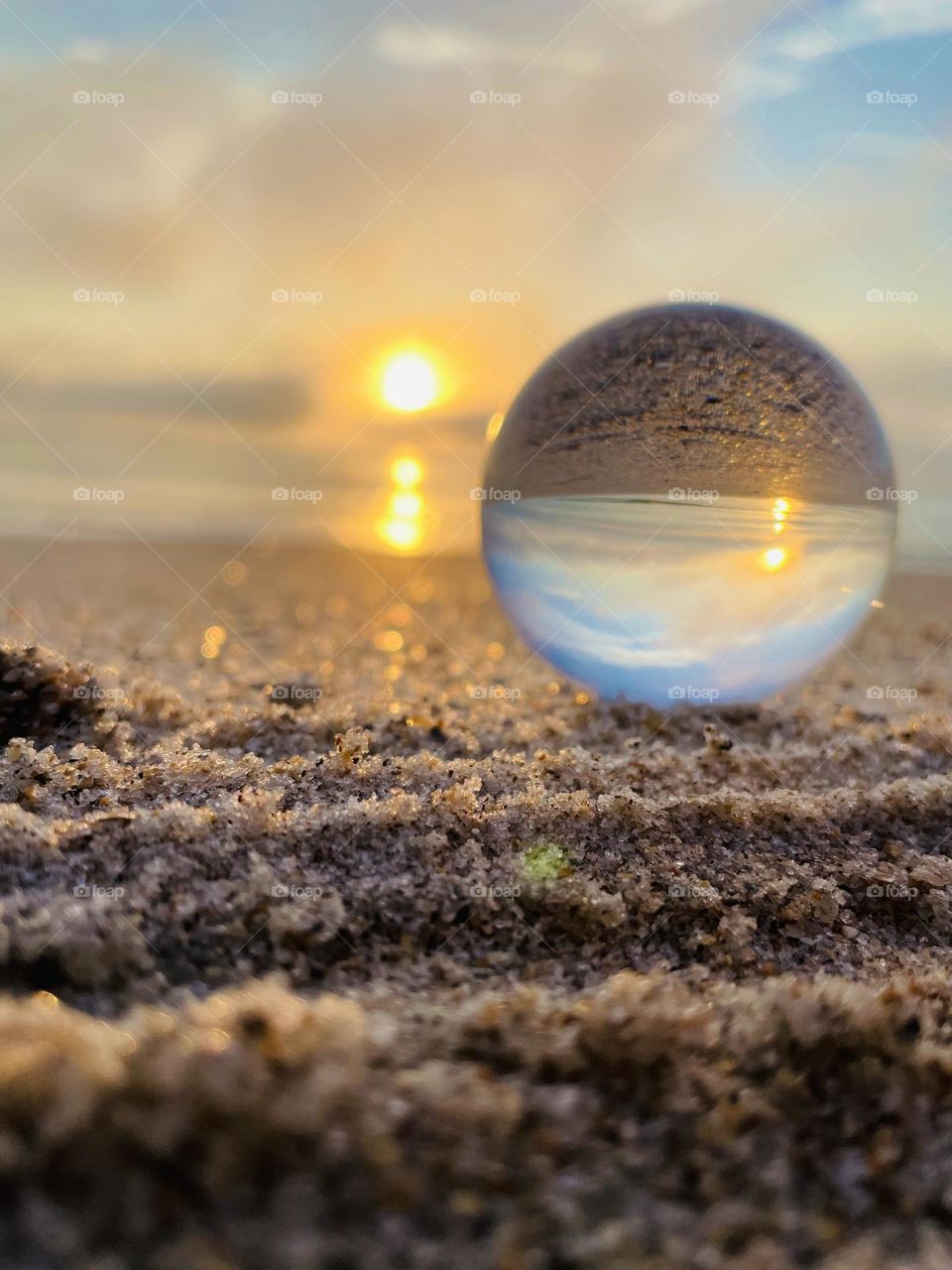 A lensball on the sea shore at sunrise on the beach