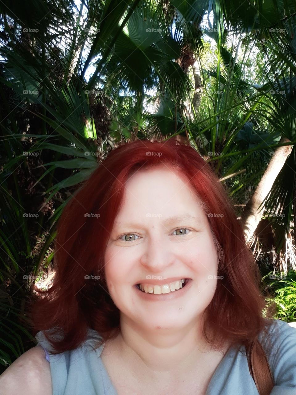 Selfie taken of myself a Caucasian woman with red hair, I am smiling and enjoying nature at Mead Botanical Gardens in Winter Park, Florida.
