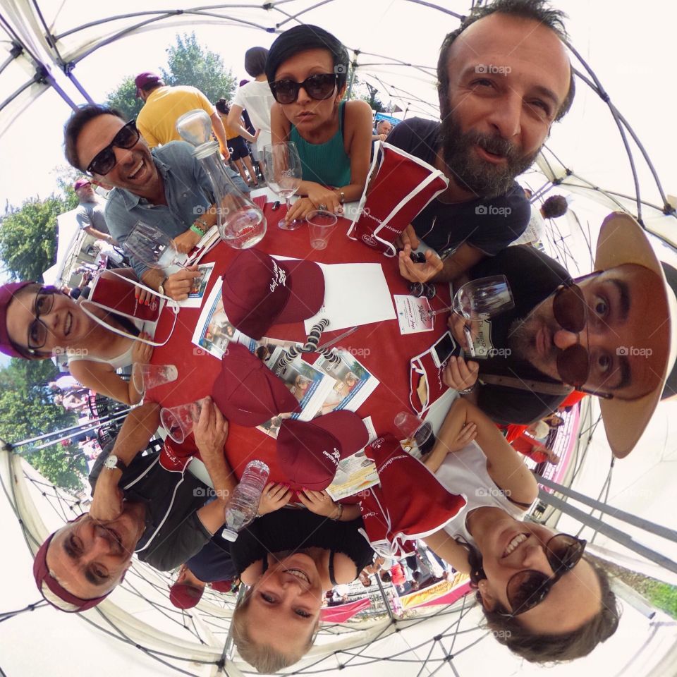 Group of friends sitting circular in restaurant with funny face