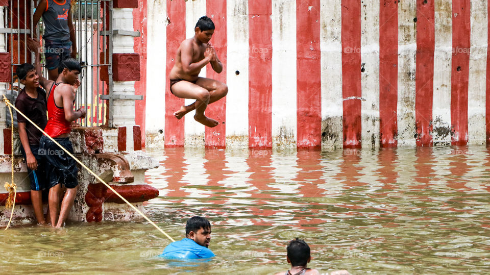 A Funfull story of this summer time is river bathing.... A boy doing fun stunt in water.. Summer memories