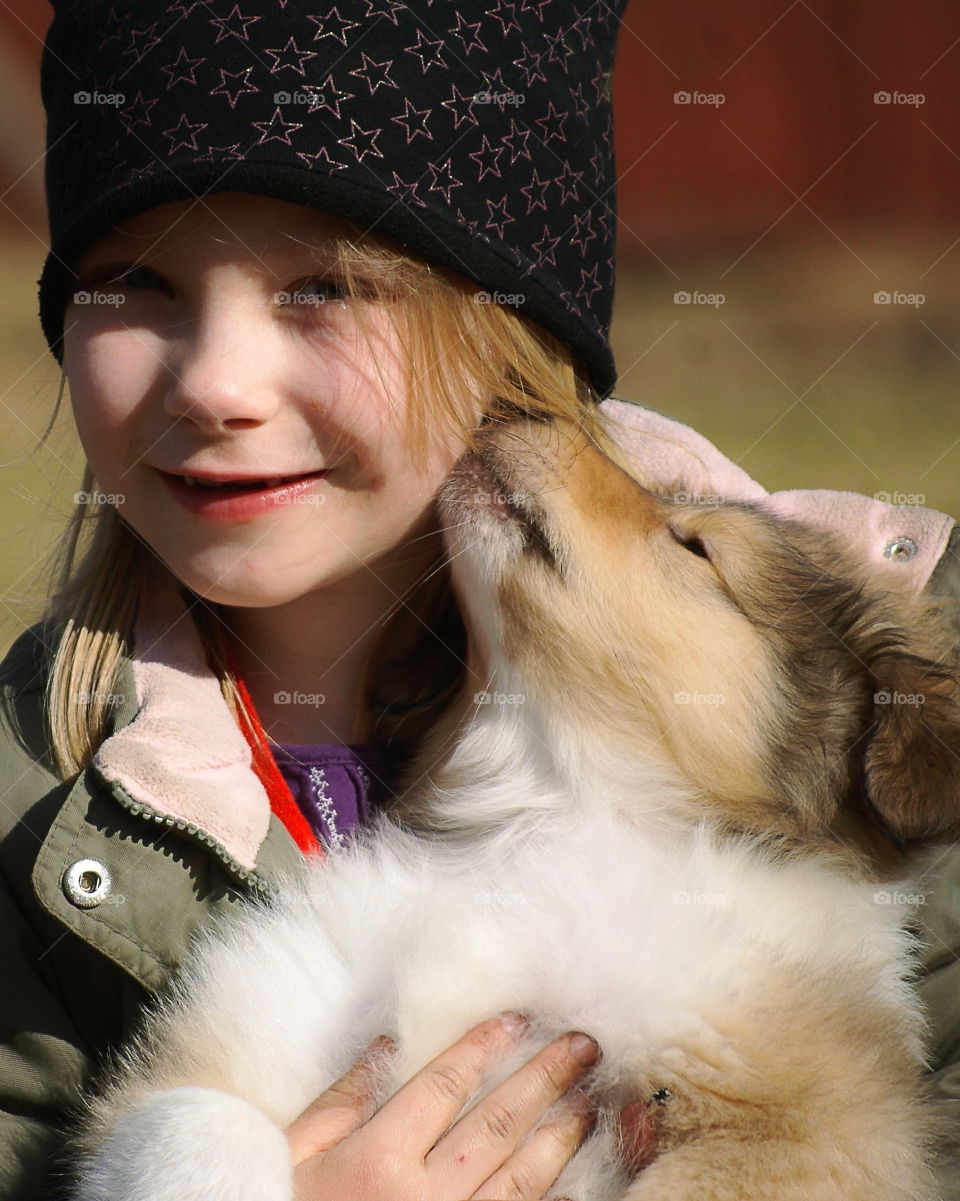 Puppy licks a girl in the face