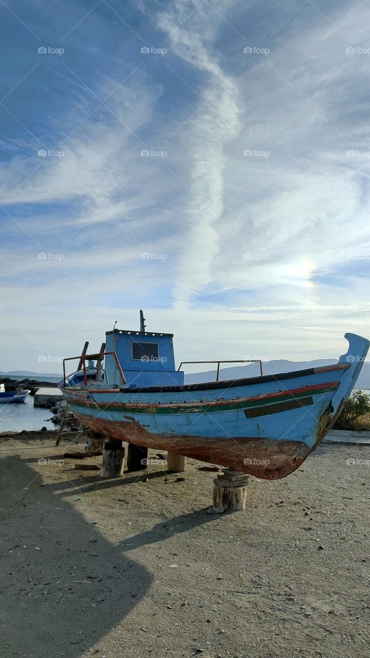 Beautiful sky and an old boat. Clouds come floating into your heart.