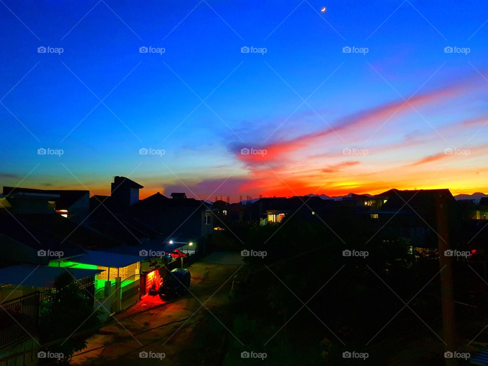 Cloudy sky early in the morning, clouds just before sunrise, the clouds refract the red adn yellow color, the sky is blue an dark