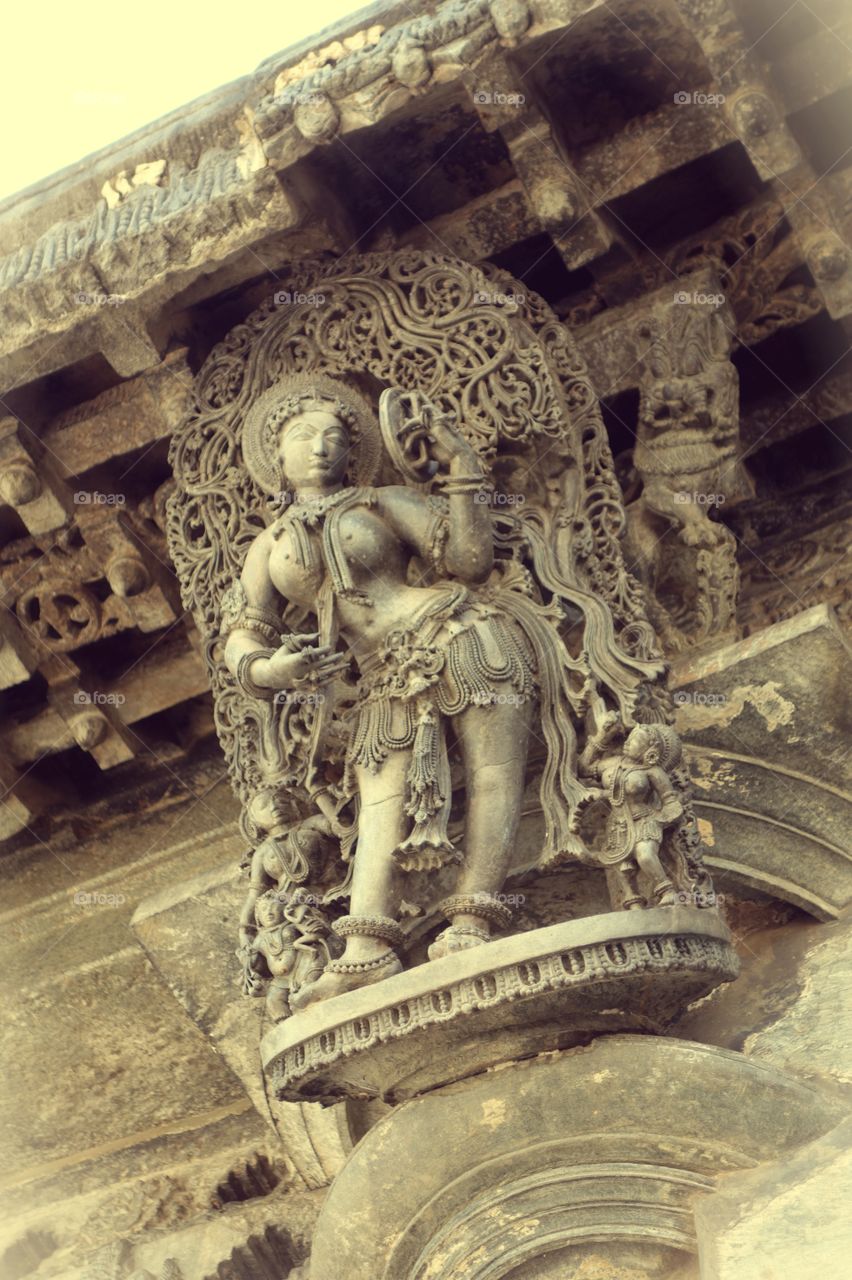 Belur Chennakeshava temple Apsara Dharpana Sundari - seeing her face in the mirror while applying cosmetic