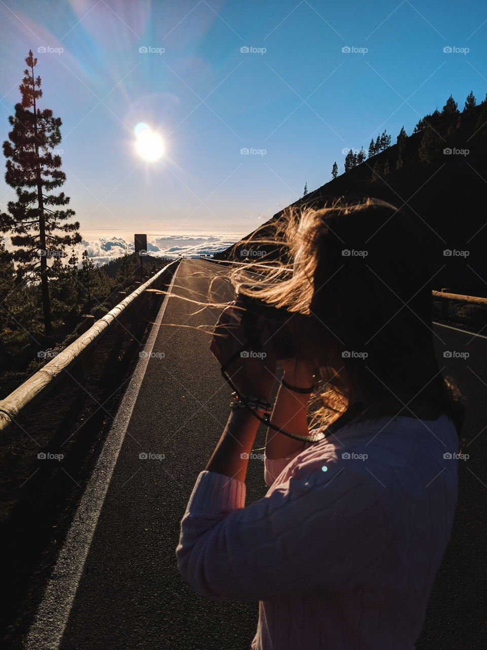 Woman is taking a photo of sun