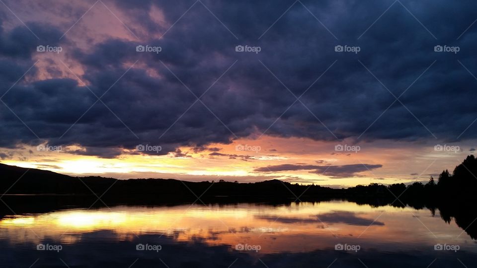 yellow Sunset with dramatic clouds reflected in lake