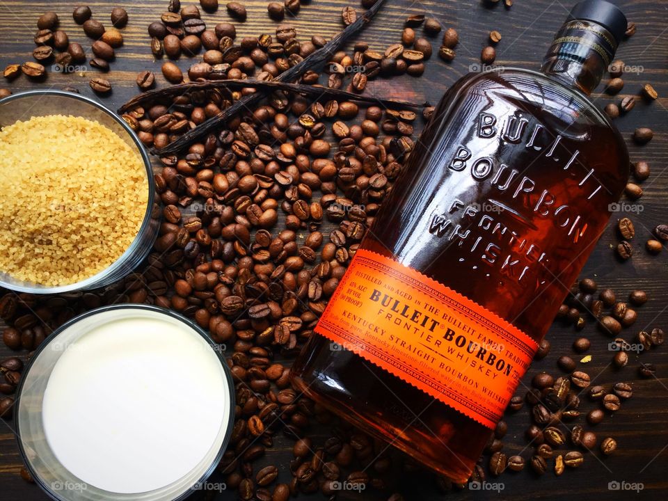Ingredients for vanilla-bourbon coffee with Bulleit Bourbon on a dark wood background