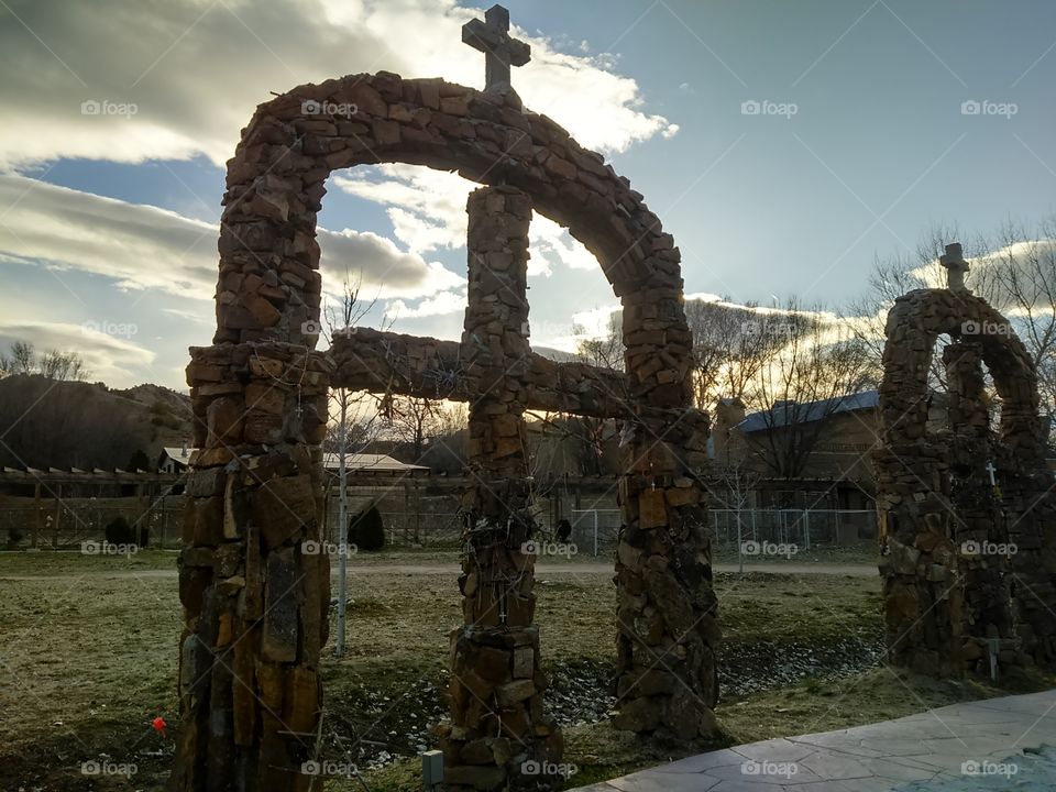 Large religious cross archway made with rock
