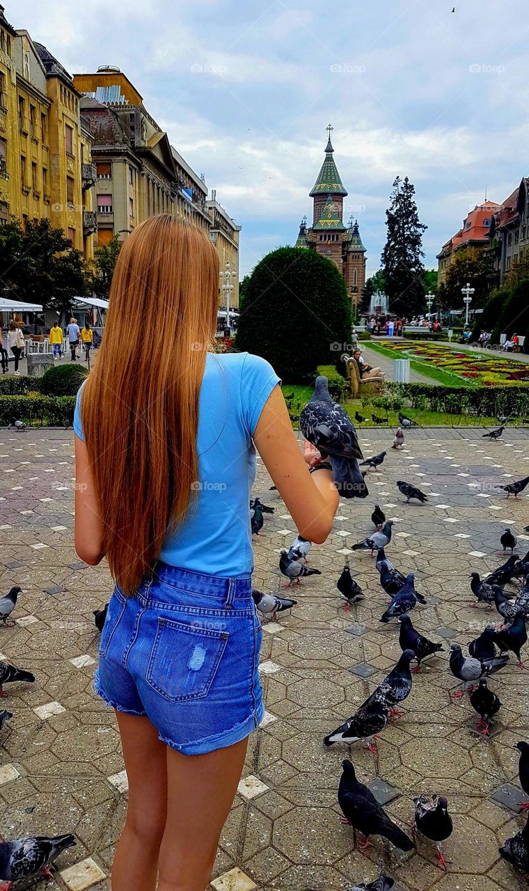 the girl with golden hair holds a dove in her hand