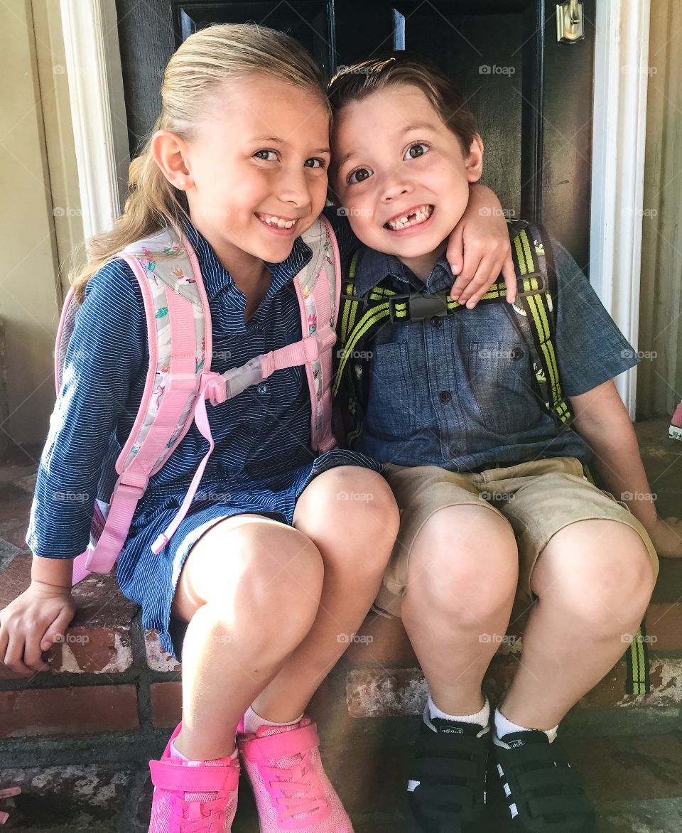 Siblings sitting near steps