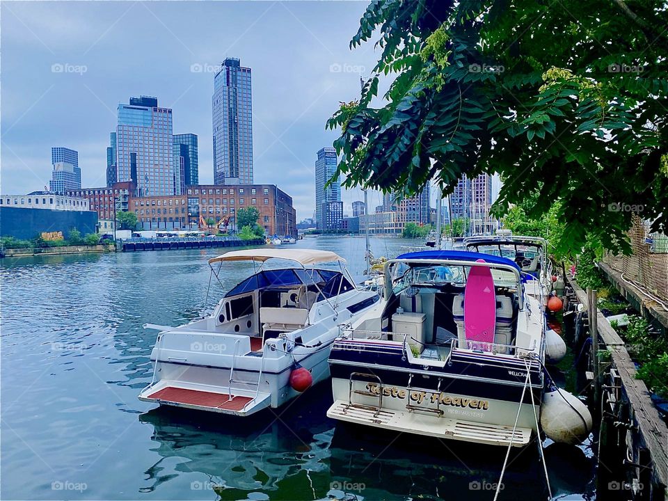 „Newtown Creek“ in LIC has something to offer in any kind of weather. The sea appears smooth, still and brightly shimmering today. „Greenpoint“, Bklyn is on the left, „Queens“ on the right and „Manhattan“ straight ahead. 2023. Hypnotic Productions