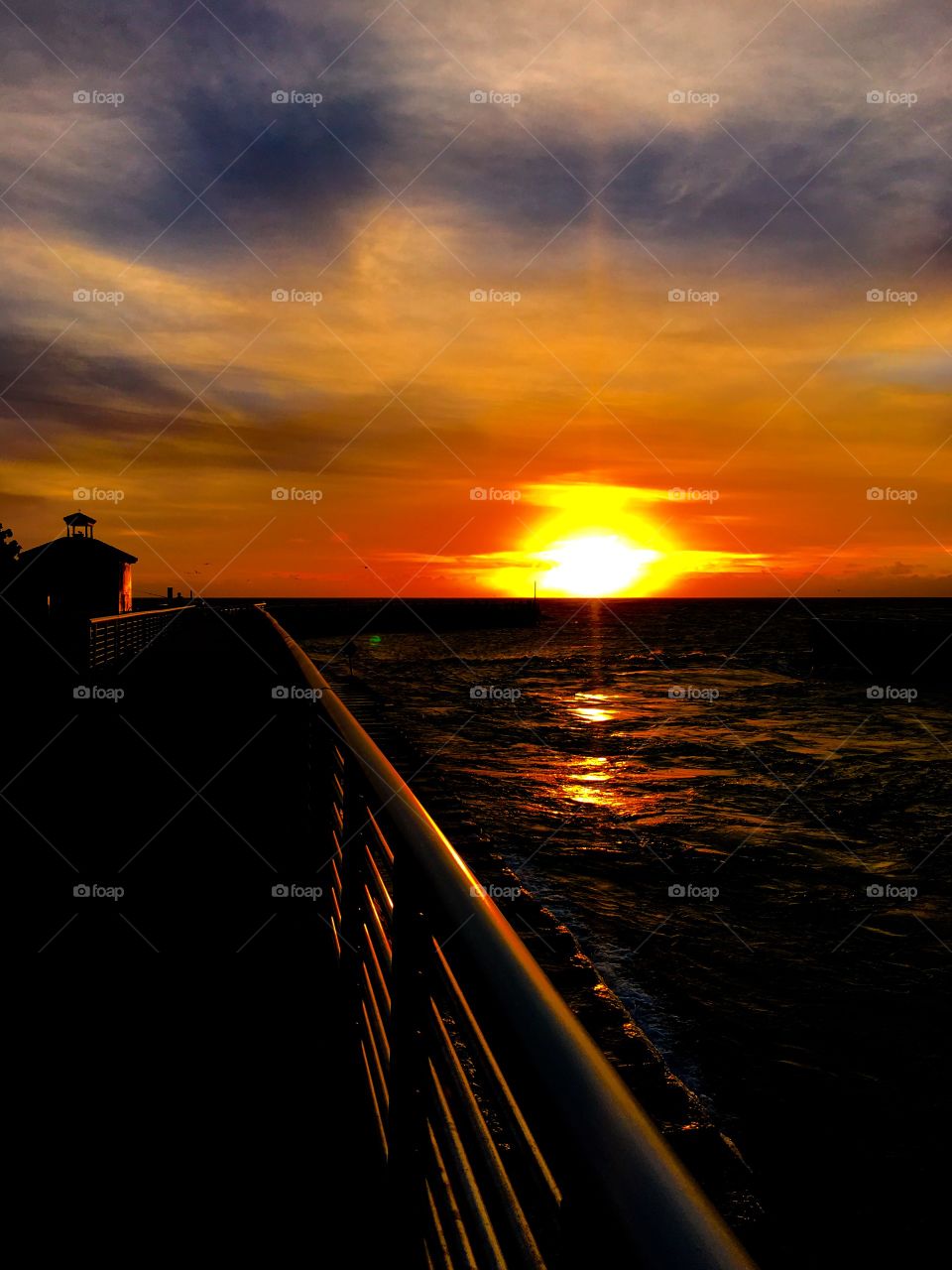 Railing near the sea at sunset