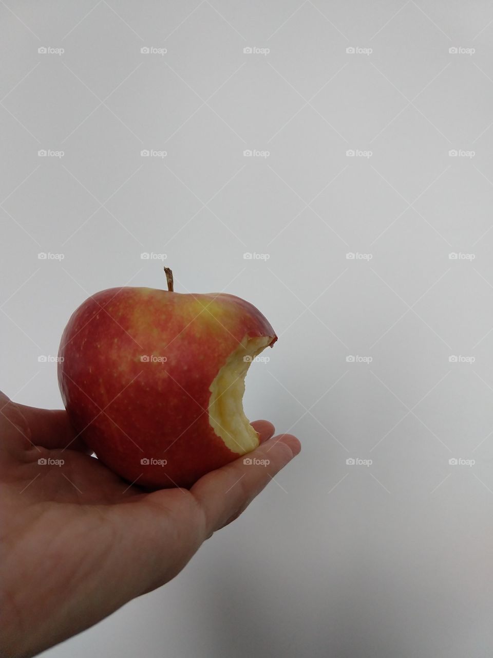 Hand holding an apple with a bit part. Slovakia