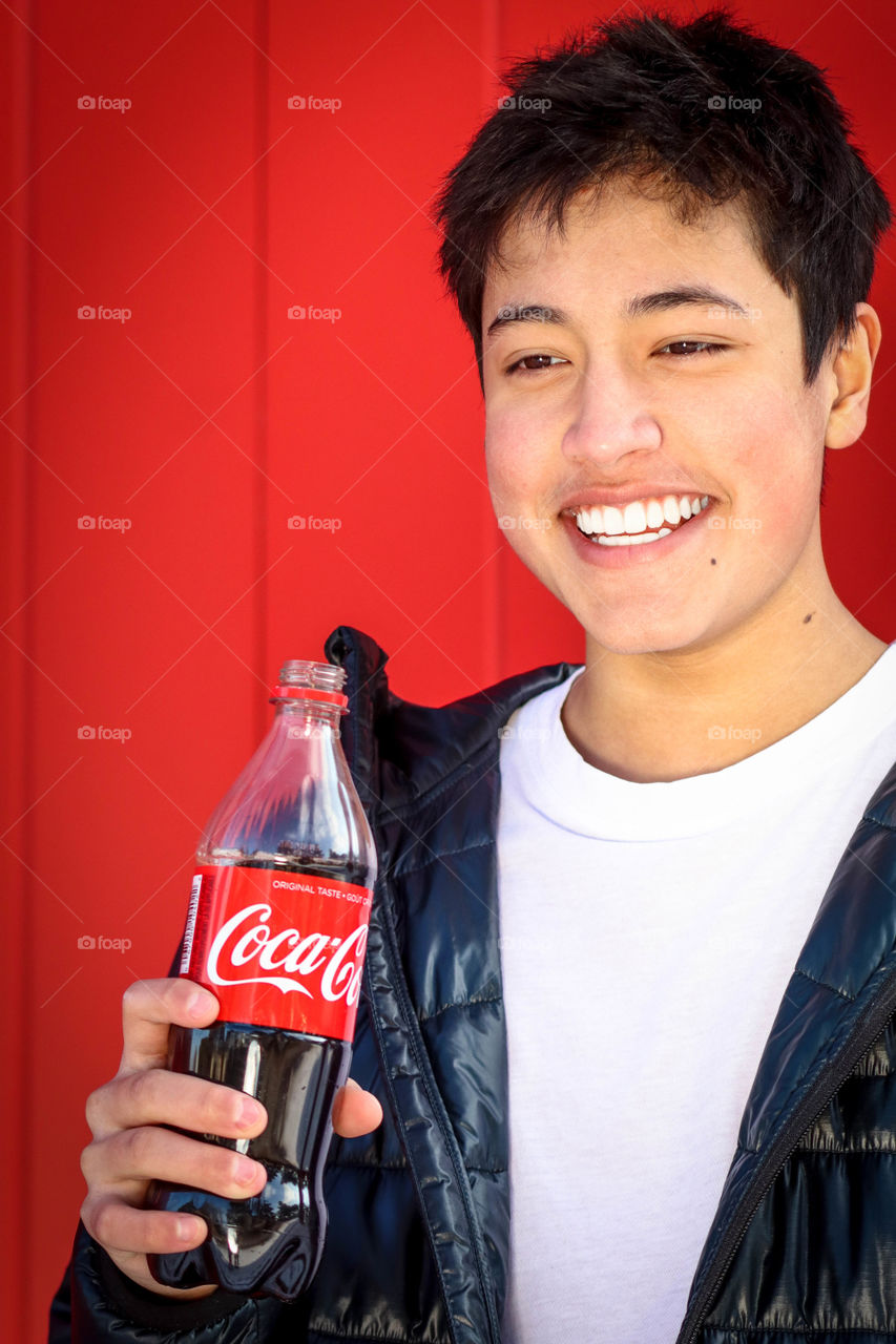 Young handsome man with a bottle of Coca-Cola