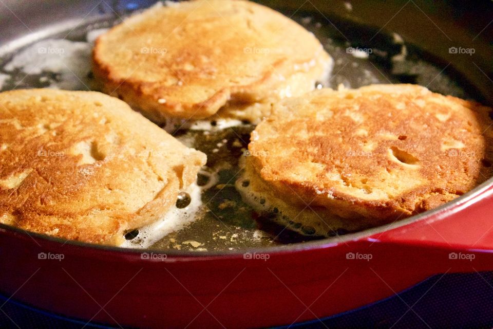 (Soaked) Whole wheat  pancakes frying in a cast iron skillet