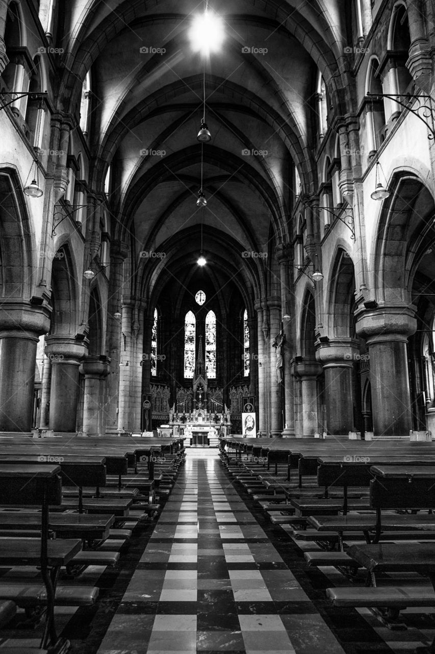 Symmetrical interior of cathedral in black and white with pillars and pews. Beautiful inside church image
