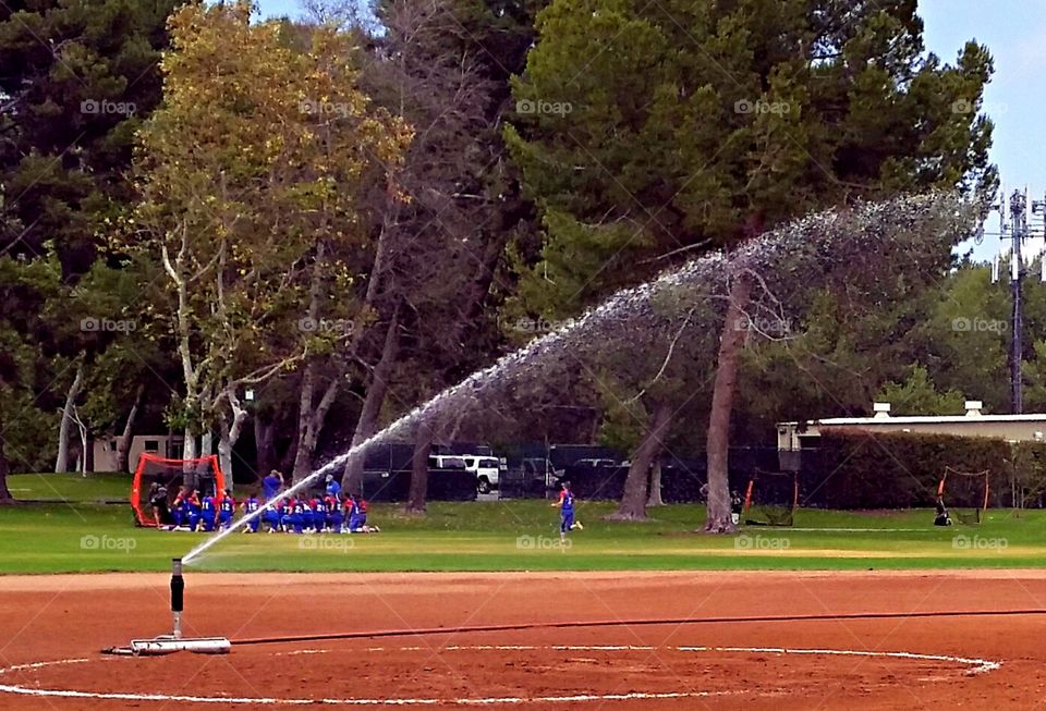 Watering down the field.. Watering down the softball field before the game.