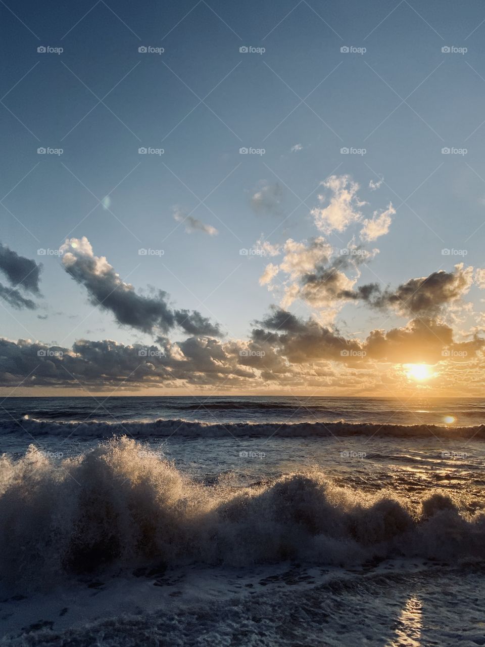 Sea waves splashing on sunset with cinematic clouds