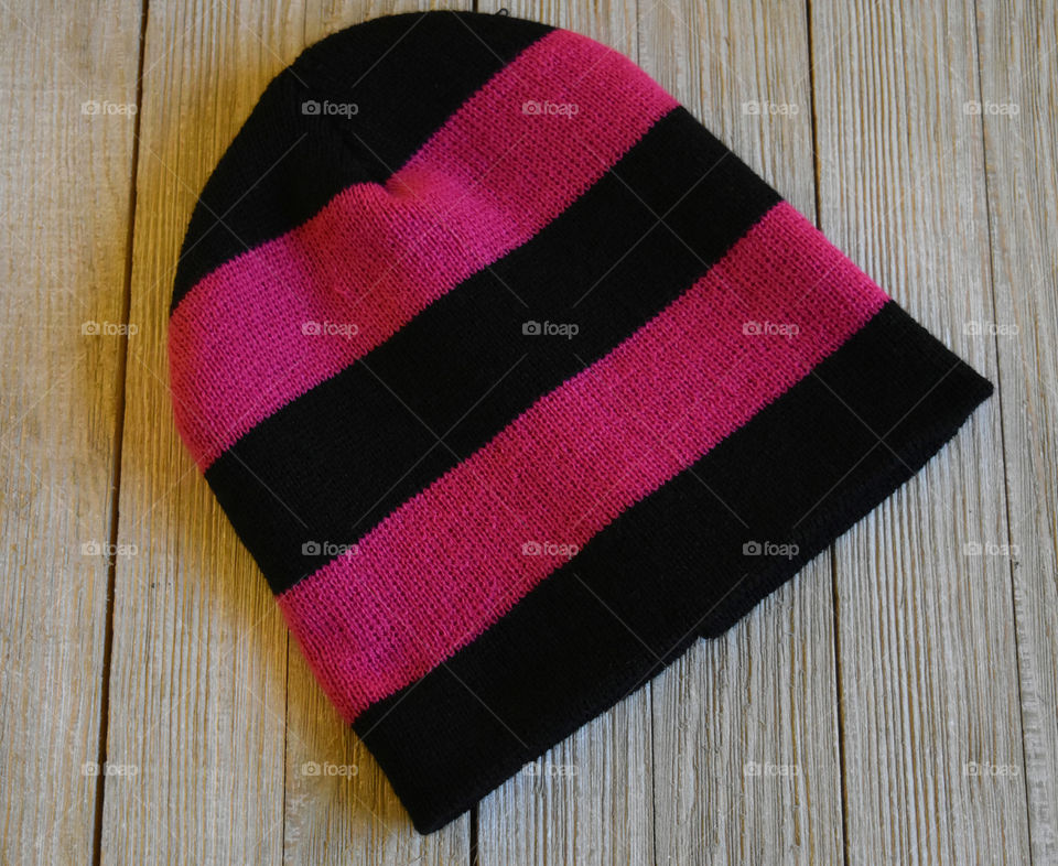 Striped winter hat on wood background